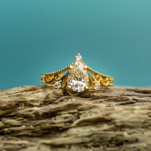 Tiara inspired, Pear shaped diamond and 14k gold engagement ring.