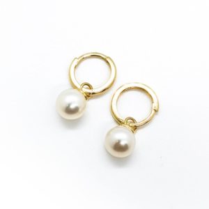A pair of yellow gold hoop earrings with large pearls hanging from them.