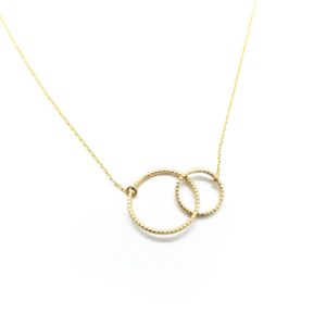 A yellow gold dainty necklace with a large hoop intertwined with a smaller hoop.