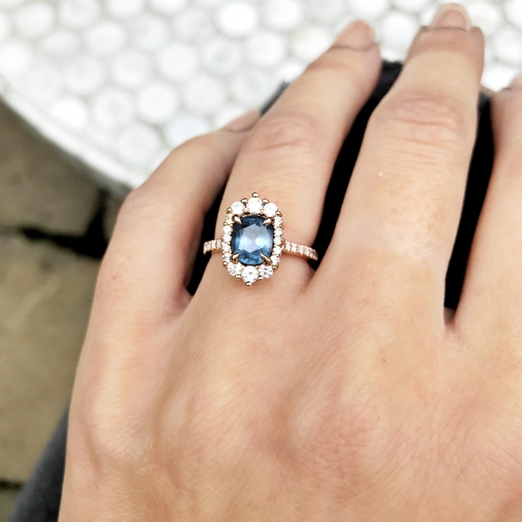 Vintage inspired alternative engagement ring featuring an oval blue Spinel and diamond halo.