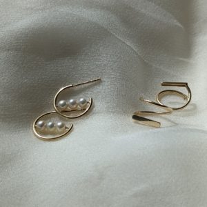 Gold hoop studs earrings with a bar of 3 pearls going through the centre and faux double loop earrings that spin through your earlobe to make it seem like you have two piercings.