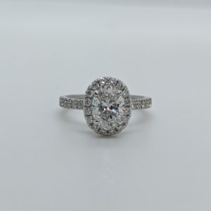 Oval diamond engagement ring with halo and pave band in white gold.